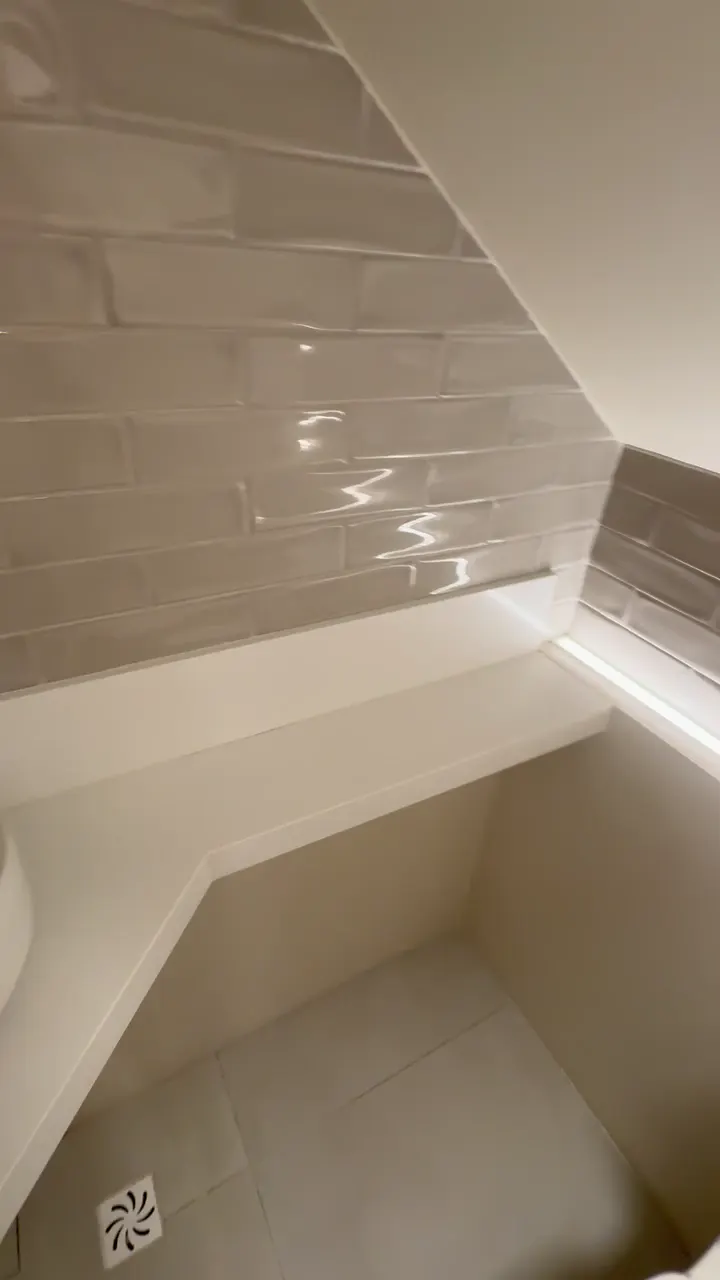 Nicho iluminado com revestimento tipo metrô no lavabo