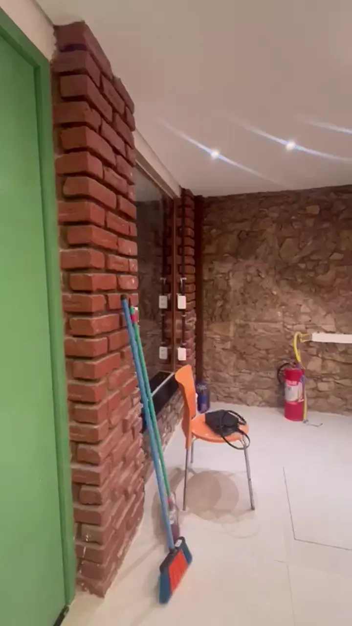 A mesma parede de pedra com piso claro novo e forro com spots de luz