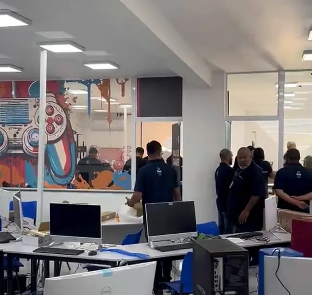 Laboratório em uso, com equipe circulando entre as bancadas de computadores
