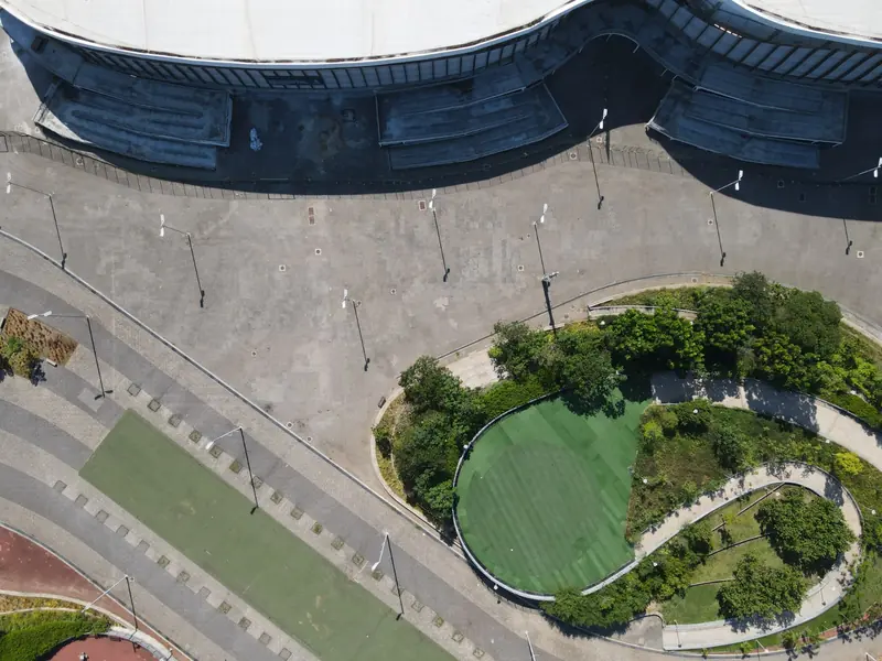 Vista aérea de canteiro oval e calçada cinza antes da obra