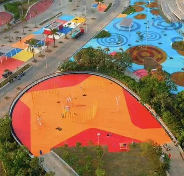 Vista aérea de praça com piso laranja e brinquedos