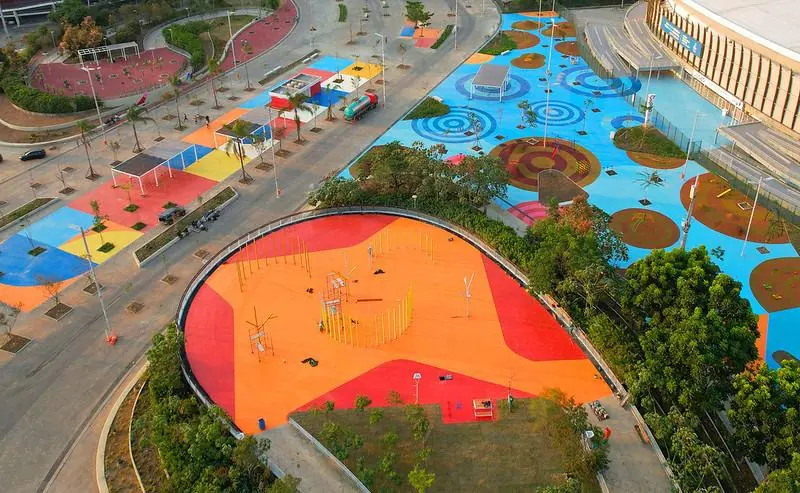 Calçadão com piso laranja e azul e ilhas de grama