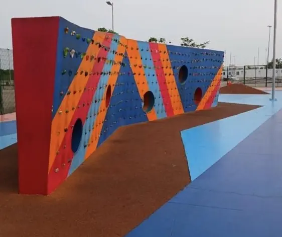 Muro de escalada colorido sobre piso laranja e azul