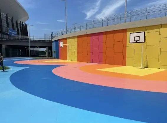 Quadra com piso azul e laranja e paredes pintadas em faixas