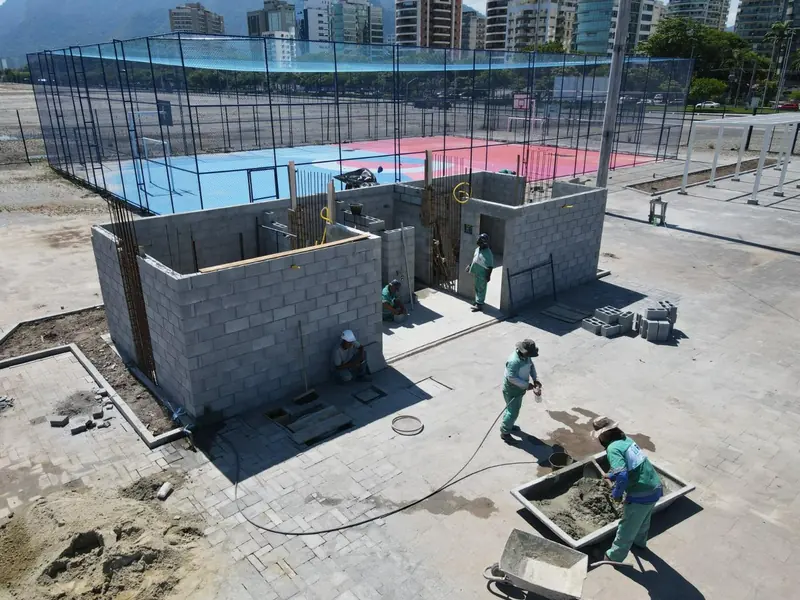 Construção de estrutura em blocos ao lado de quadra cercada