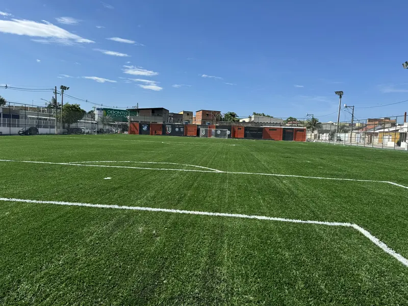 Campo com gramado sintético novo e linhas brancas de demarcação