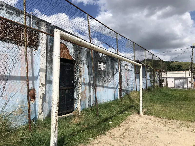 Muro azul descascado, com mofo e trave enferrujada