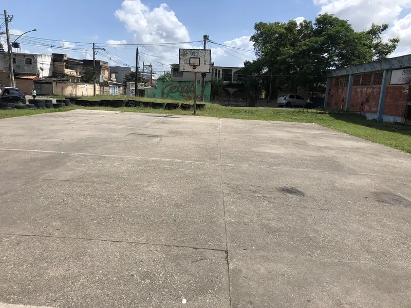 Quadra de cimento rachada e desbotada antes da obra