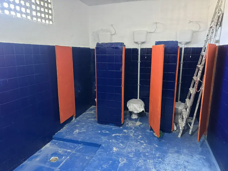 Box sanitário com bacia, divisórias e azulejo azul até meia parede