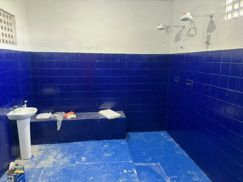Lavatório e área de banho do vestiário com piso azul